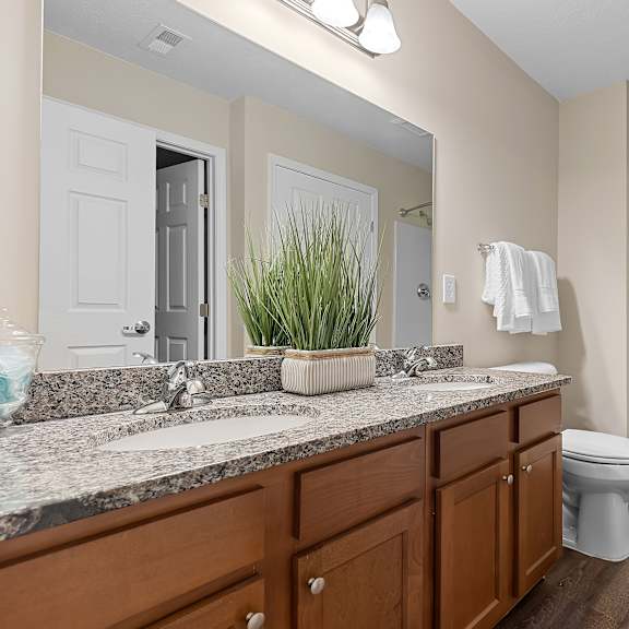 a bathroom with a toilet, sink, and shower.
