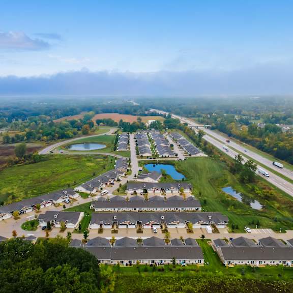 a bird's eye view of a residential area with houses and a lake.