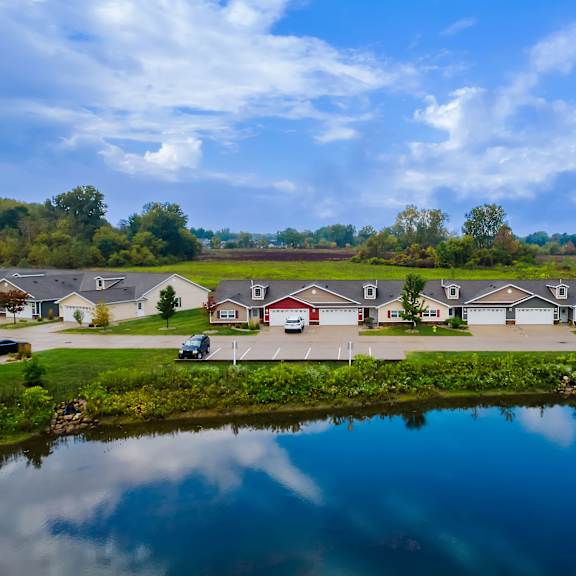 a serene residential area with houses and a pond.