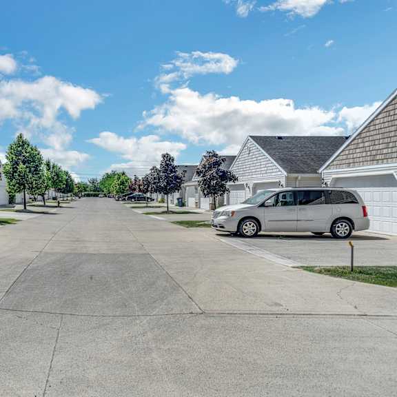a residential street with cars parked on both sides.