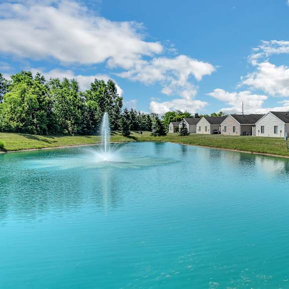 a serene lake with a fountain in the middle of it.