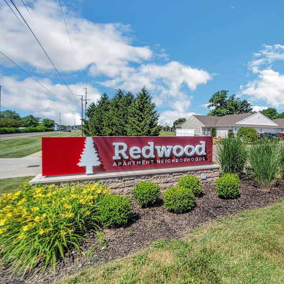 a sign for redwood apartment homes is in front of a building.