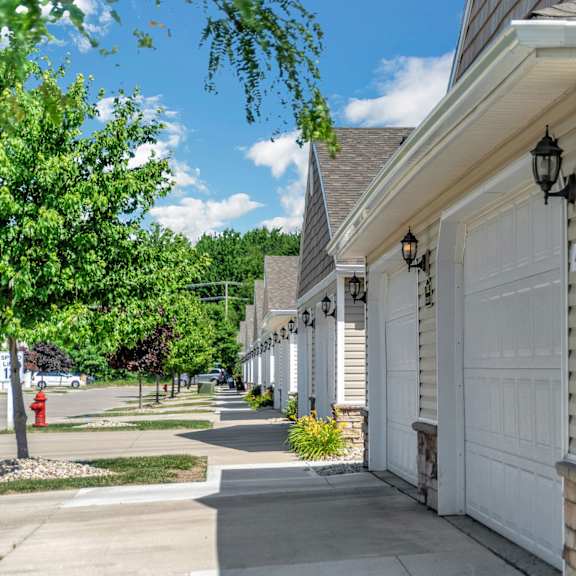 a row of houses with white garage doors.