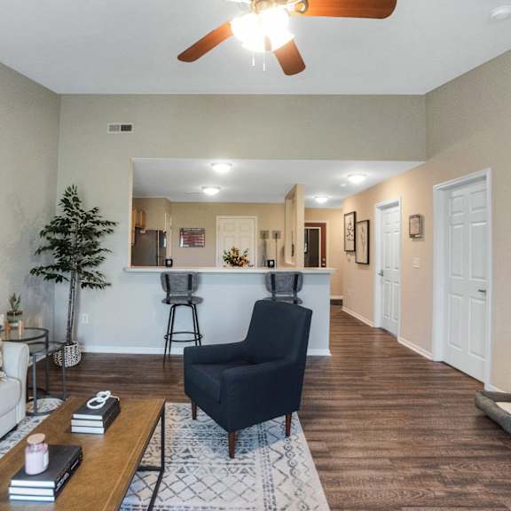 a living room with a white couch, a black chair, and a painting on the wall.
