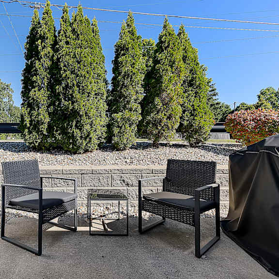 a patio with a white fence and a table with chairs.