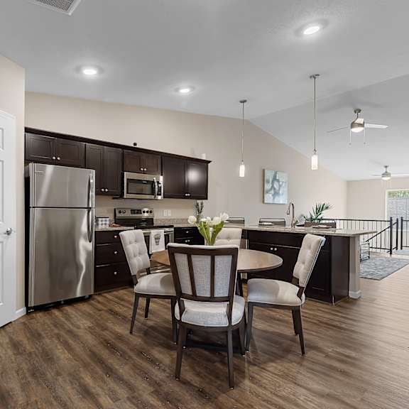 a kitchen with a table and chairs in the middle of the room.