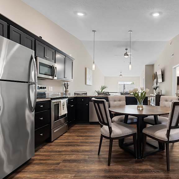 a modern kitchen with a dining table set for two.