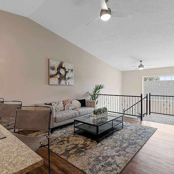 a modern living room with a glass coffee table and a painting on the wall.