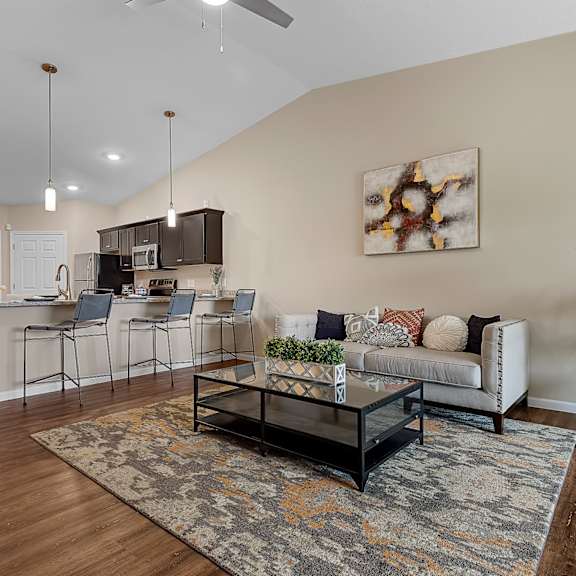 a living room with a couch, chairs, and a rug.