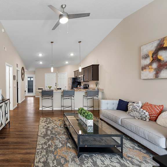 a living room with a white couch and a television on the wall.