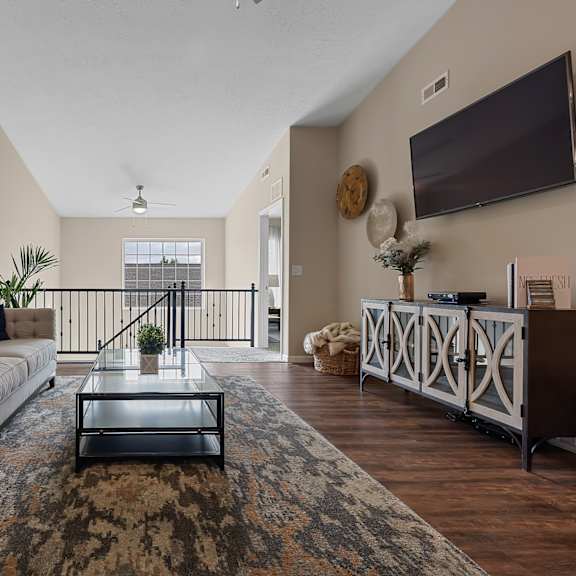 a living room with a couch, a coffee table, and a television.