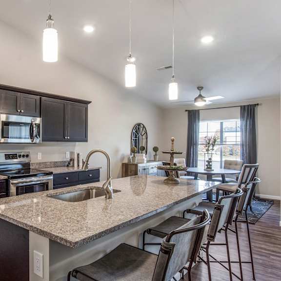 a modern kitchen with a granite countertop and stainless steel appliances.