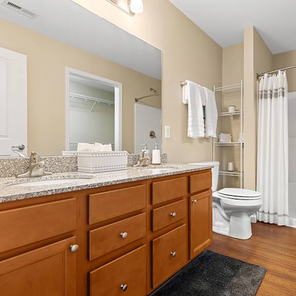 a bathroom with a toilet, sink, and shower.