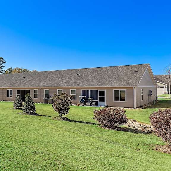 a house with a grey roof and a green lawn.