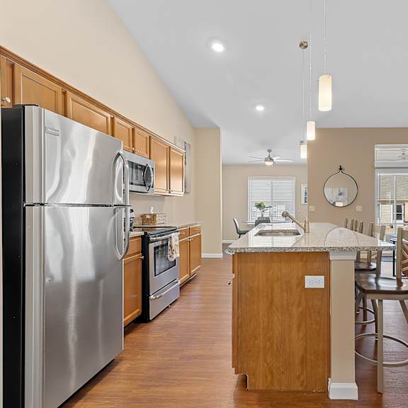 a modern kitchen with a large island and stainless steel appliances.