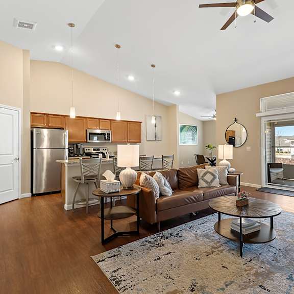a modern living room with a kitchen in the background.