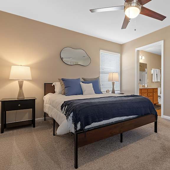 a bedroom with a bed, nightstand, and a ceiling fan.