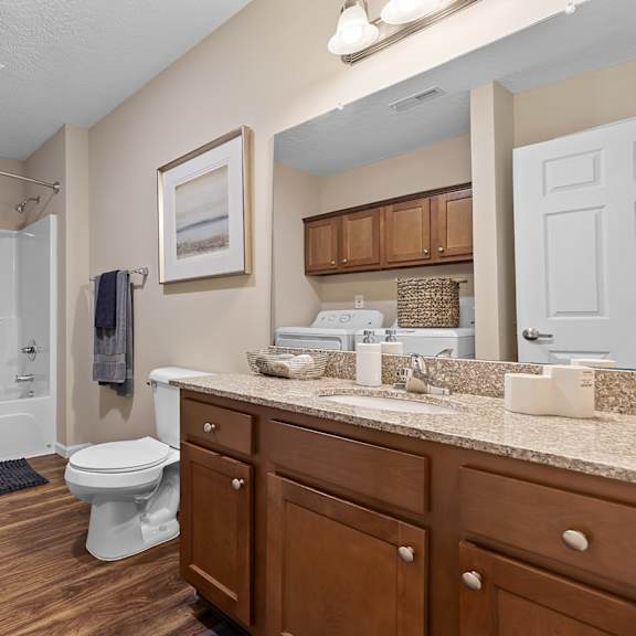 a bathroom with a toilet, sink, and shower.