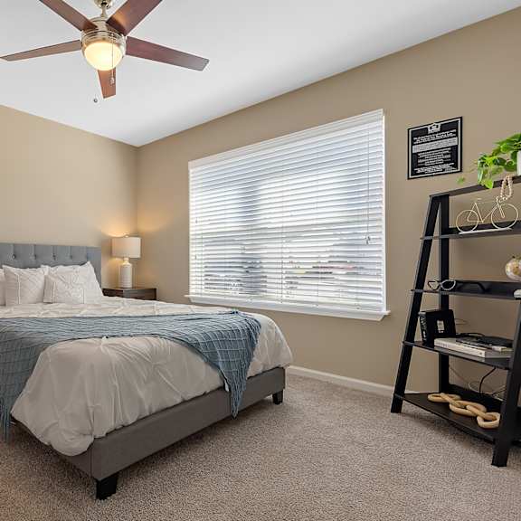 a bedroom with a bed, nightstands, and a ceiling fan.