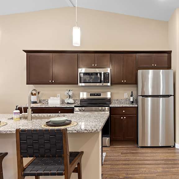 a kitchen with a refrigerator, sink, and cabinets.