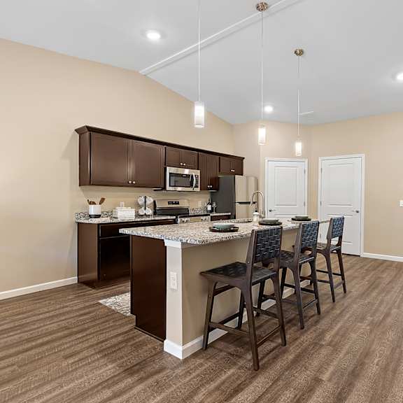 a kitchen with brown chairs and brown cabinets.