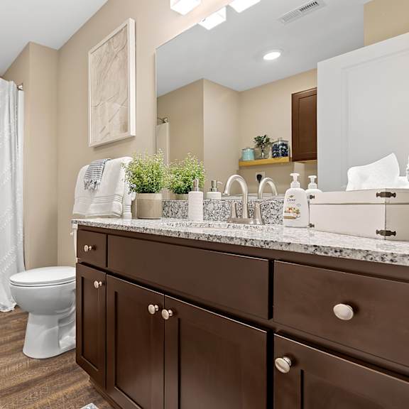 a bathroom with brown cabinets and a white toilet.