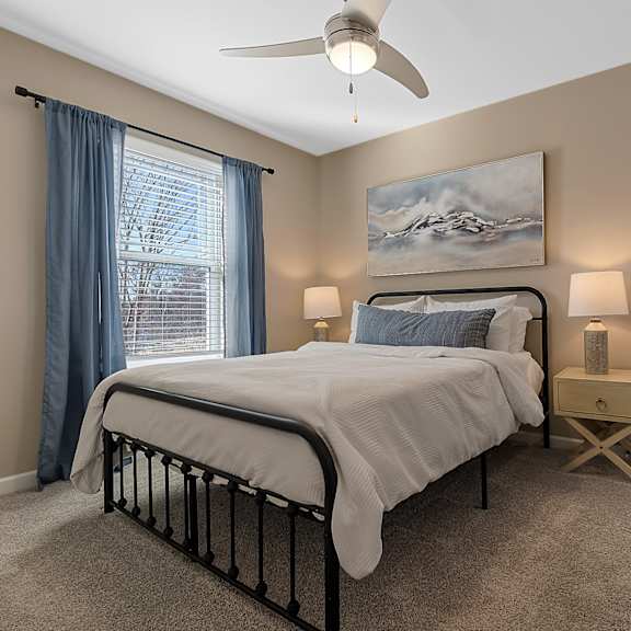 a bedroom with a bed, nightstand, and a painting on the wall.