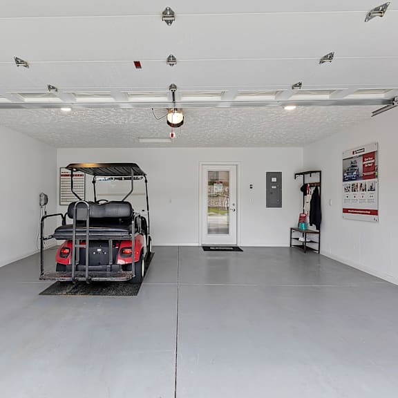 a white room with a black vehicle and a white door.