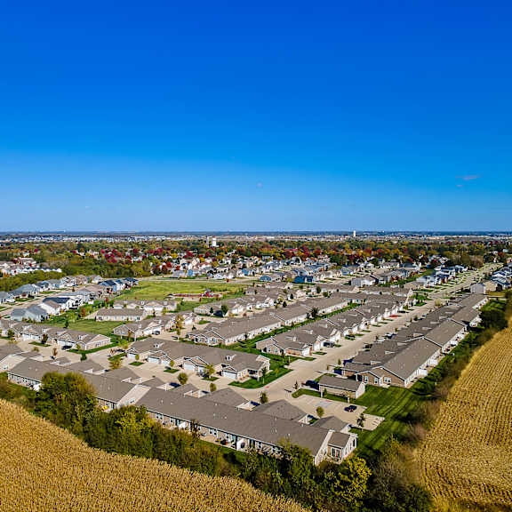 a bird's eye view of a residential area with houses and a crop field.