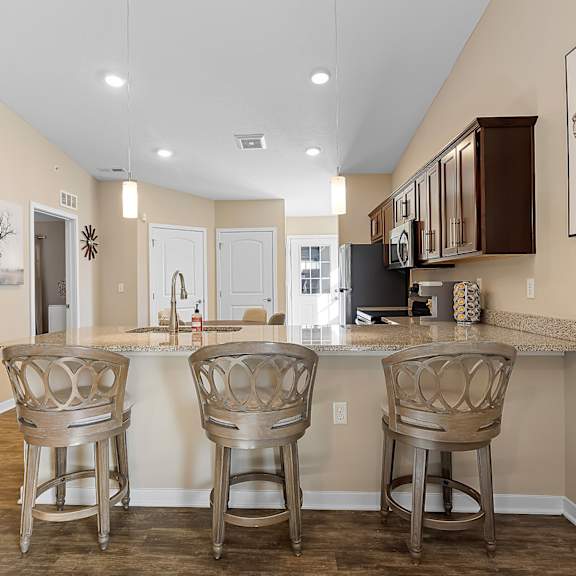 a kitchen with a bar area and chairs.