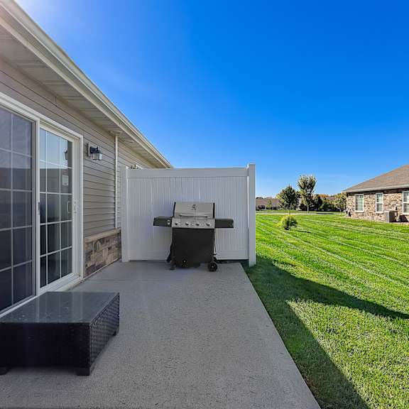 a sunny day at a residential area with a house and a patio.