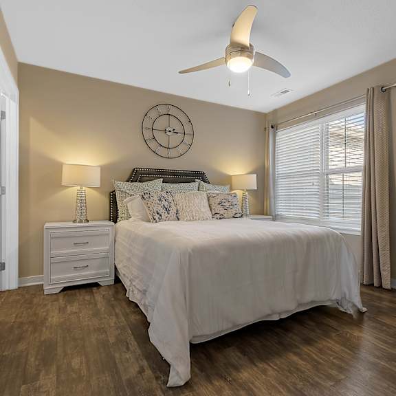 a bedroom with a bed, nightstand, and a ceiling fan.