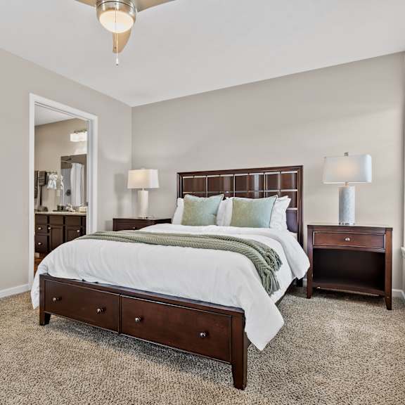 a bedroom with a large bed and a chandelier.