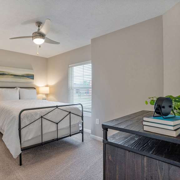 a bedroom with a bed, nightstands, and a ceiling fan.