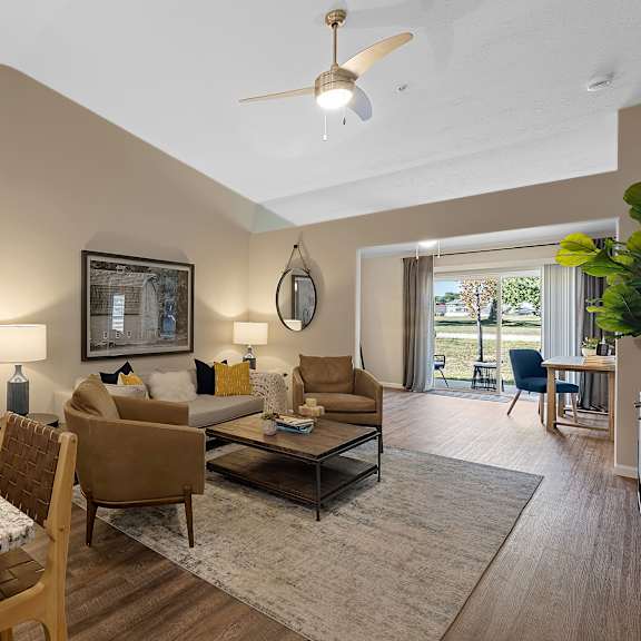 a well-lit living room with a dining table and chairs.
