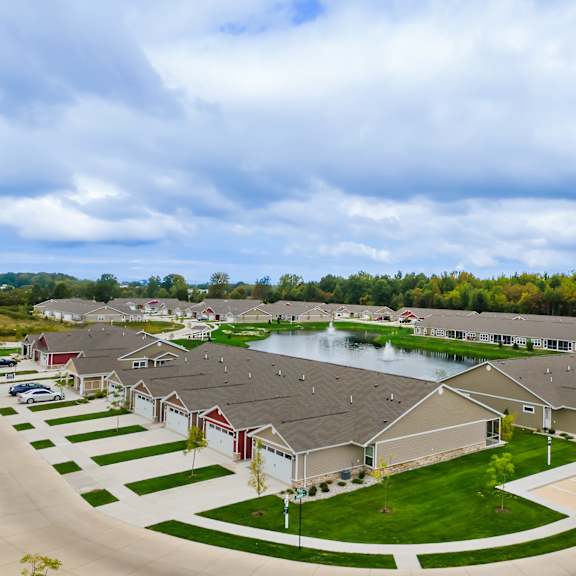 a suburban neighborhood with houses and a pond.