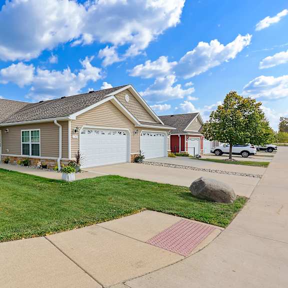 a house with a driveway and a tree in front.