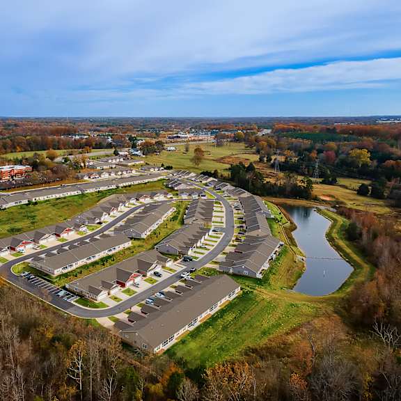 a bird's eye view of a residential area with houses and a lake.
