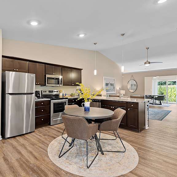 a kitchen with a table and chairs in the middle of the room.