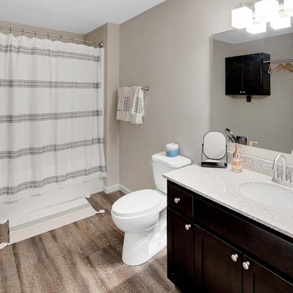 a bathroom with a white toilet, a sink, and a shower curtain.