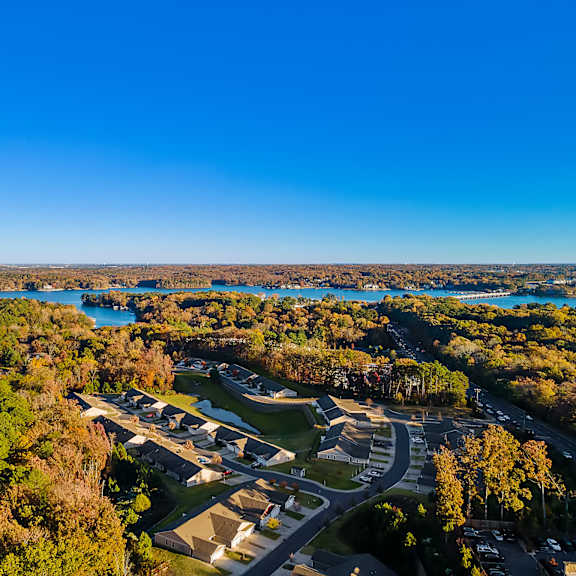 a bird's eye view of a residential area with a lake in the background.
