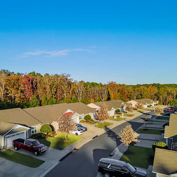 a residential street with houses and parked cars.