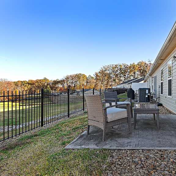 a patio with a table and chairs is in front of a house.