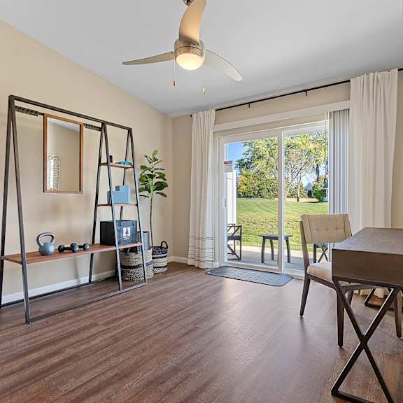 a room with a wooden floor and a table with a plant on it.