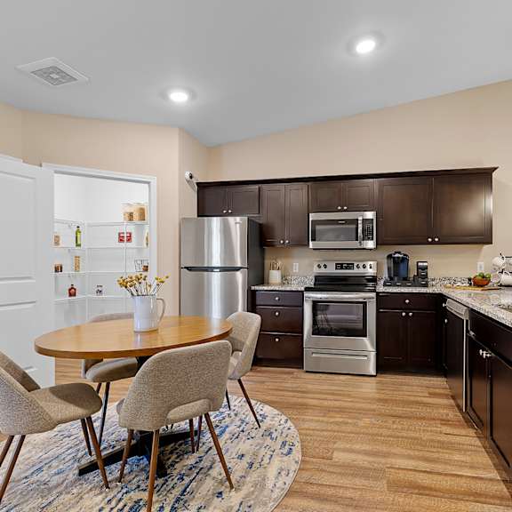 a kitchen with a table and chairs in the middle of the room.