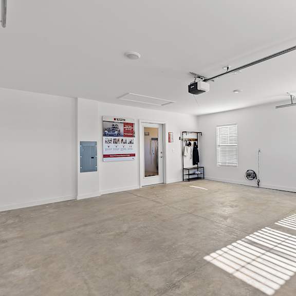 a white room with a rug on the floor and a black pipe on the ceiling.
