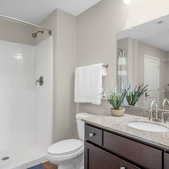 a bathroom with a toilet, sink, and shower.