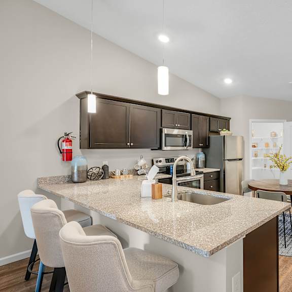 a kitchen with a table and chairs in front of a sink.