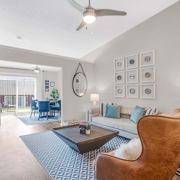 a living room with a brown leather chair and a blue patterned rug.