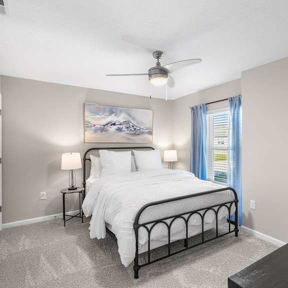a bedroom with a large bed and a painting on the wall.